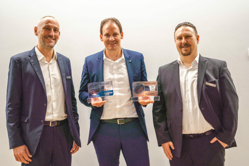 Von links nach rechts auf dem Foto: Georg Goedeckemeyer (IVFP), Volker Bohn (Die Stuttgarter), Manuel Lang (IVFP). Volker Bohn hält die beiden Auszeichnungen in der Hand. Die drei Männer lächeln fröhlich in die Kamera.